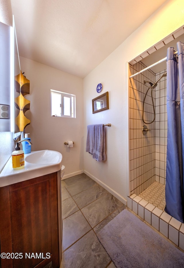 311 N Winslow Ave, Winslow, AZ 86047 - full bath featuring vanity, a tile shower, tile patterned flooring, toilet, and baseboards