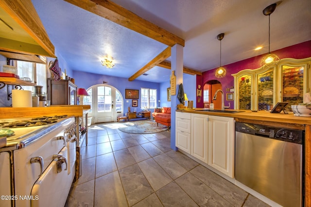 311 N Winslow Ave, Winslow, AZ 86047 - kitchen with dishwasher, a sink, arched walkways, beam ceiling, and white cabinets