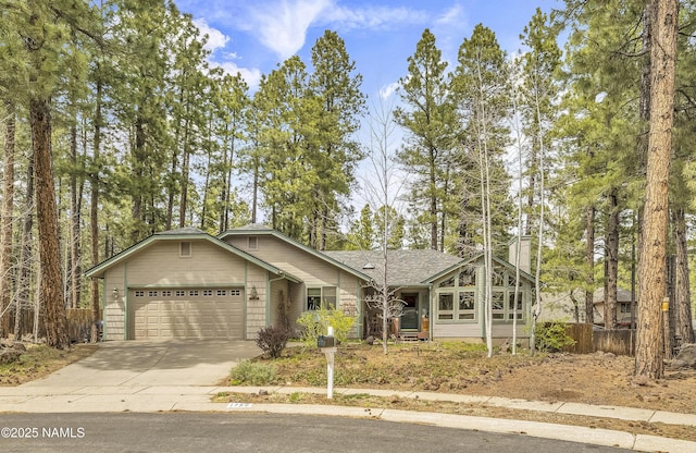 ranch-style house featuring fence, roof with shingles, a garage, a chimney, and driveway