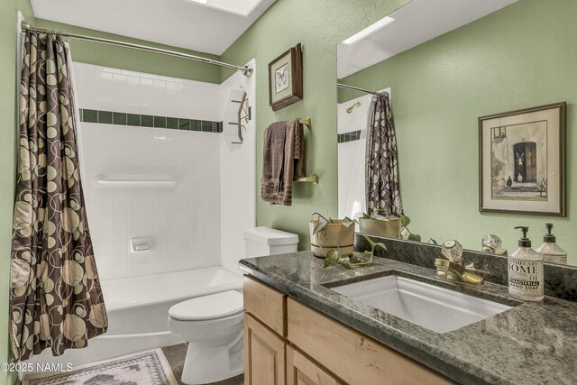 full bath with vanity, shower / tub combo, and toilet