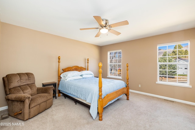 bedroom with a ceiling fan, light colored carpet, visible vents, and baseboards