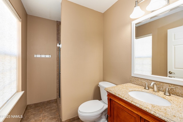 bathroom featuring tile patterned flooring, baseboards, vanity, and toilet