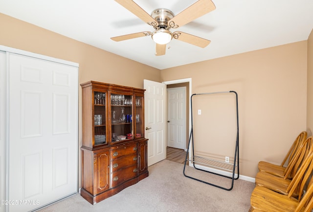 sitting room with light colored carpet, ceiling fan, and baseboards