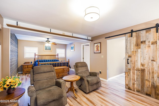 bedroom featuring light wood-style floors, baseboards, and a barn door