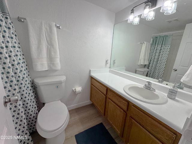 1807 N Main St, Flagstaff, AZ 86004 - full bathroom with visible vents, vanity, wood finished floors, toilet, and baseboards