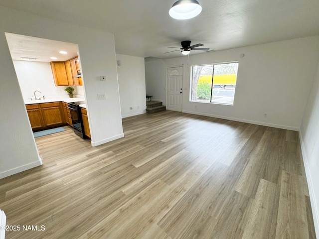1807 N Main St, Flagstaff, AZ 86004 - unfurnished living room with baseboards, a sink, light wood-style flooring, and ceiling fan