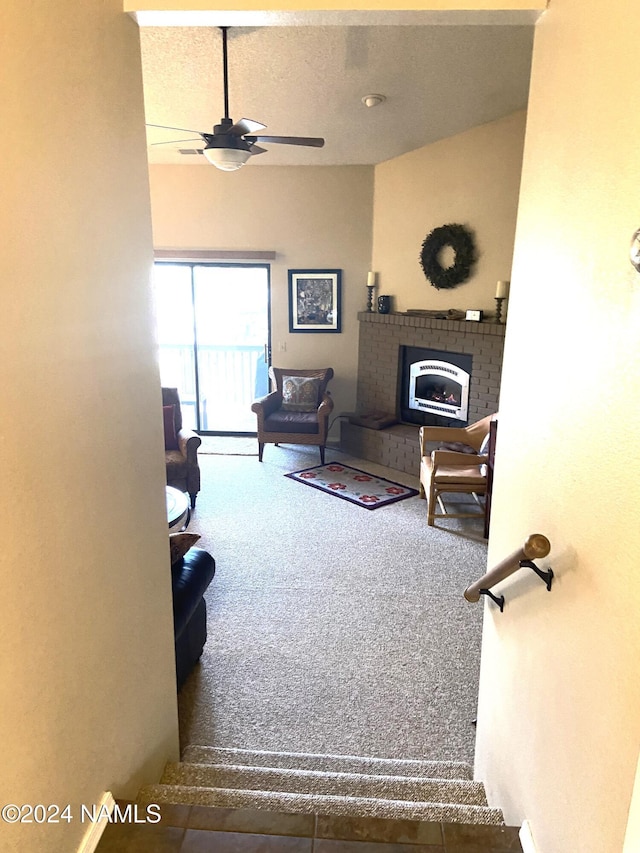 living room featuring ceiling fan, carpet, and a brick fireplace