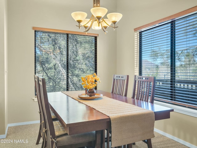 dining area with a chandelier and light carpet