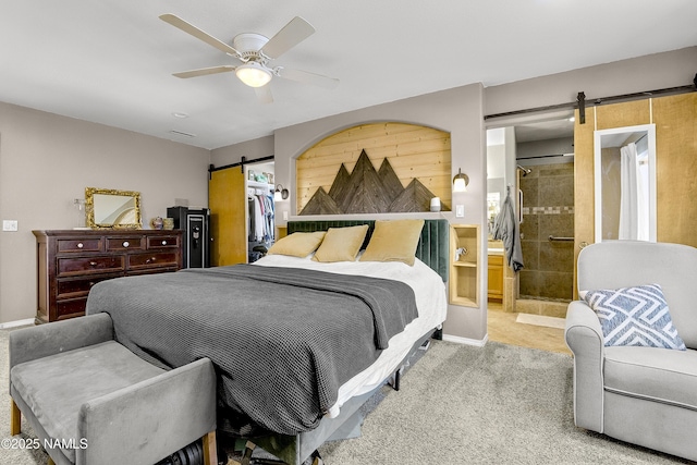 9654 Heritage Dr, Flagstaff, AZ 86004 - carpeted bedroom featuring a barn door, ceiling fan, ensuite bath, a closet, and a walk in closet