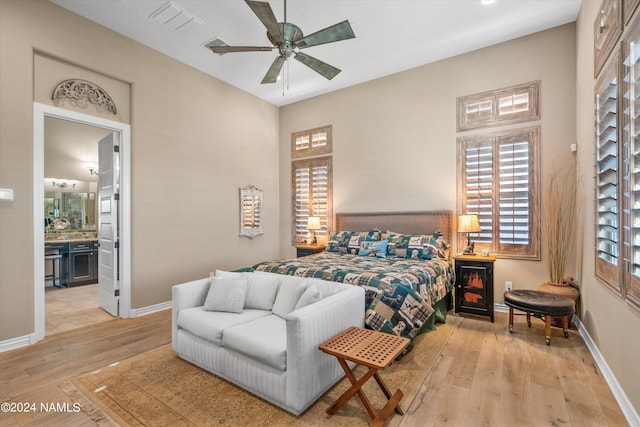 bedroom featuring ceiling fan, ensuite bathroom, and light hardwood / wood-style floors