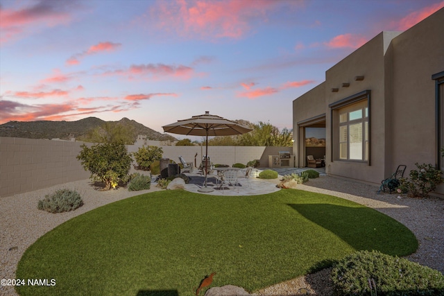 yard at dusk with a mountain view and a patio