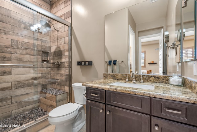 bathroom featuring toilet, vanity, and an enclosed shower