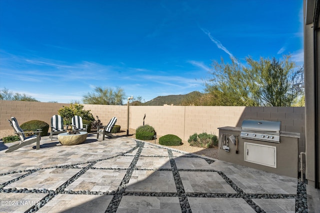 view of patio / terrace featuring a grill, a fire pit, and area for grilling