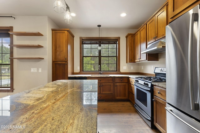 3135 Ancient Trl, Flagstaff, AZ 86005 - kitchen with stainless steel appliances, under cabinet range hood, brown cabinets, a sink, and wood finished floors