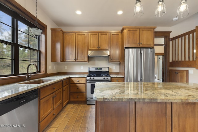 3135 Ancient Trl, Flagstaff, AZ 86005 - kitchen featuring stainless steel appliances, a sink, under cabinet range hood, brown cabinets, and recessed lighting