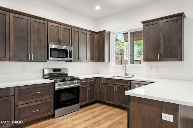 555 N Valerian Ln Lot 24, Flagstaff, AZ 86004 - kitchen featuring appliances with stainless steel finishes, a sink, dark brown cabinets, light countertops, and light wood-style floors
