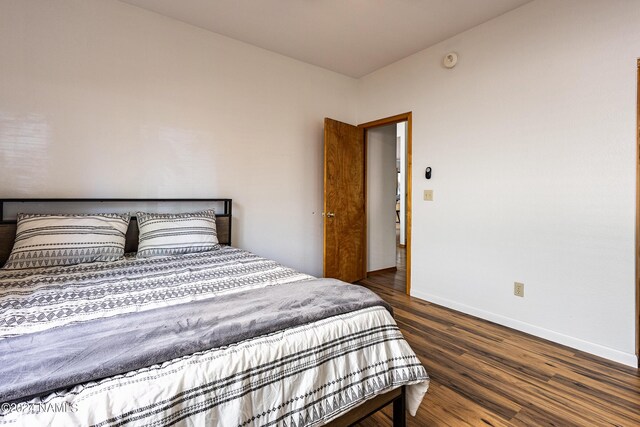 bedroom with dark hardwood / wood-style flooring