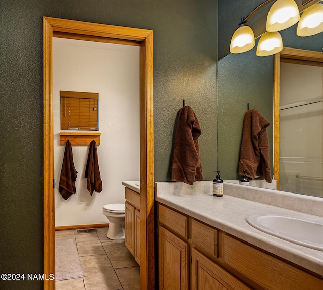 bathroom with vanity, toilet, and tile patterned floors