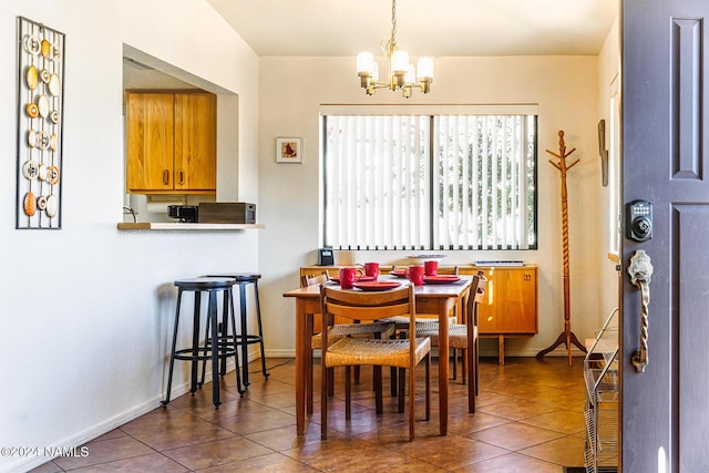 dining area with an inviting chandelier and dark tile patterned floors