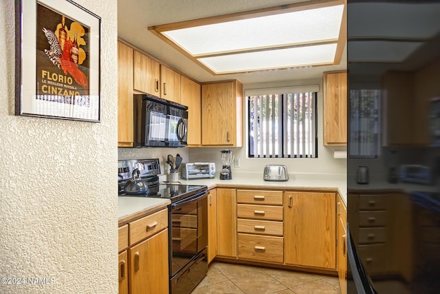 kitchen featuring black appliances and light tile patterned flooring