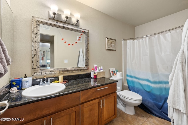 bathroom with vanity, visible vents, a textured wall, toilet, and tile patterned floors