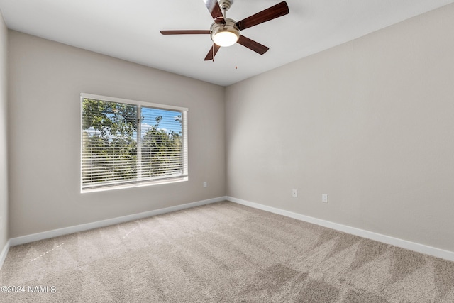 carpeted empty room featuring a ceiling fan and baseboards