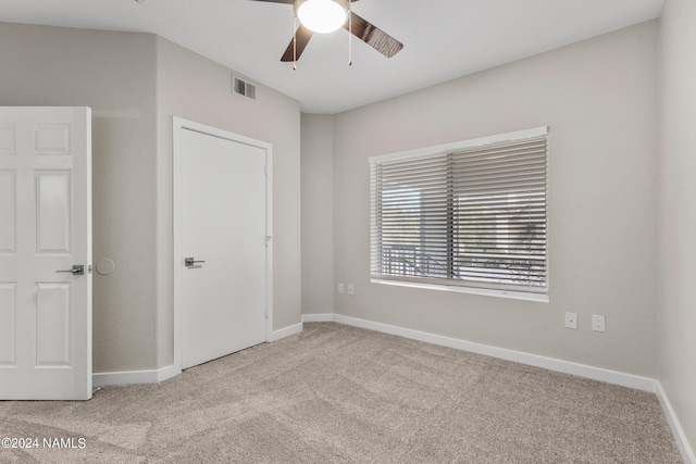 unfurnished bedroom featuring ceiling fan, carpet floors, visible vents, and baseboards