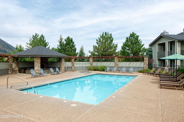 community pool featuring a patio area, fence, and a gazebo