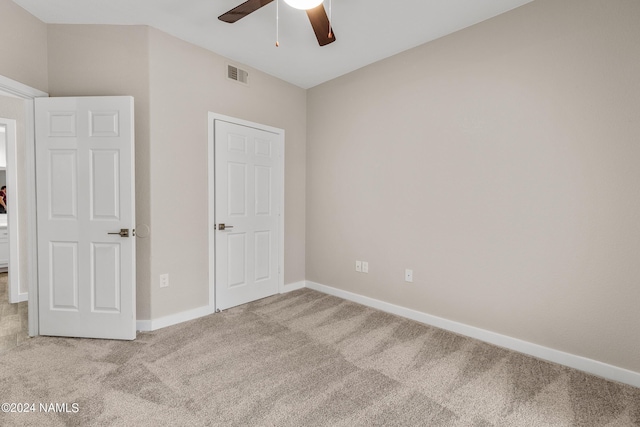 unfurnished bedroom with a ceiling fan, carpet, visible vents, and baseboards