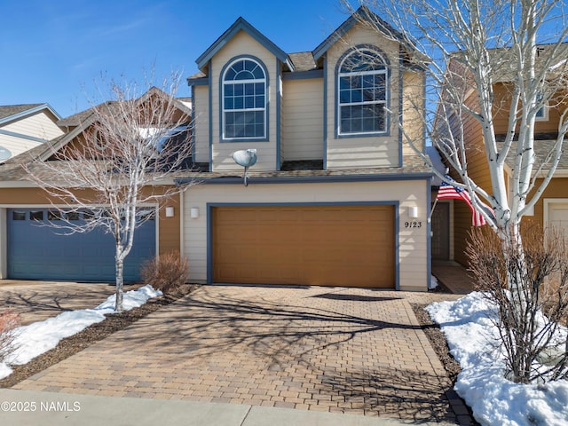 traditional-style house featuring decorative driveway and an attached garage