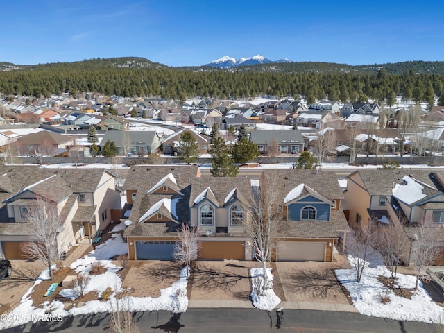 drone / aerial view with a mountain view, a view of trees, and a residential view