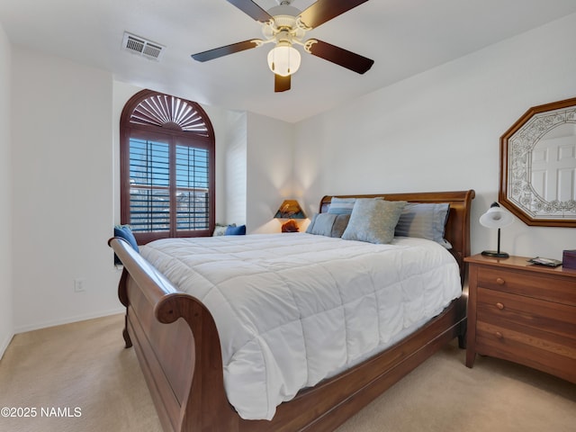 bedroom featuring visible vents, light colored carpet, baseboards, and a ceiling fan