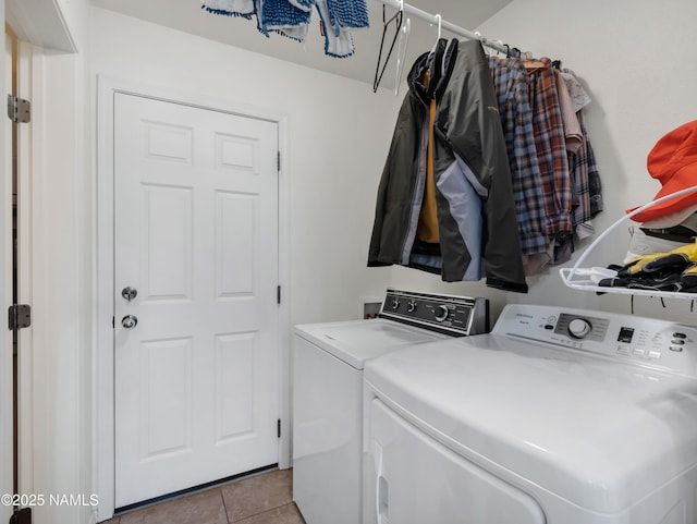 laundry room featuring light tile patterned floors, laundry area, and washing machine and clothes dryer