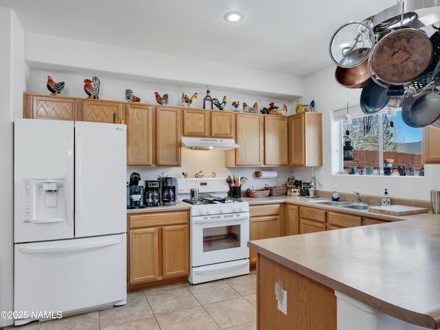 kitchen featuring under cabinet range hood, a sink, white appliances, light countertops, and light tile patterned floors