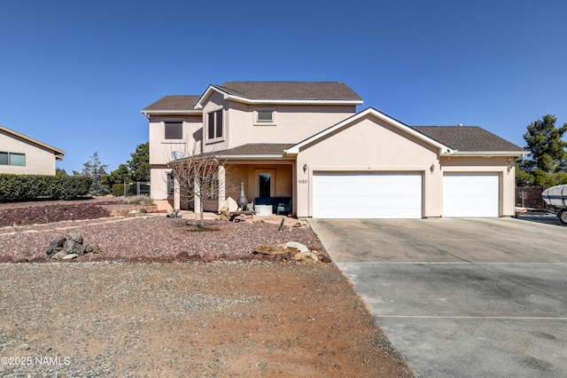 traditional-style house featuring an attached garage, concrete driveway, and stucco siding