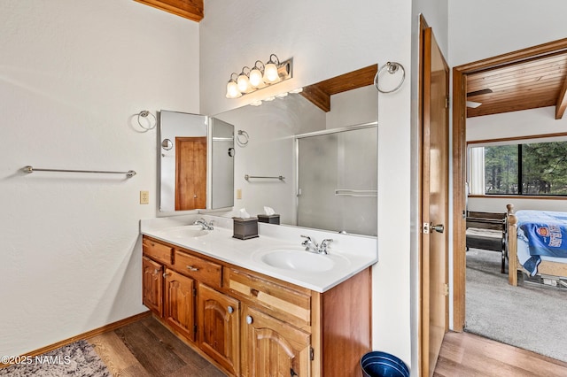 ensuite bathroom featuring wood finished floors, a shower stall, double vanity, and wood ceiling