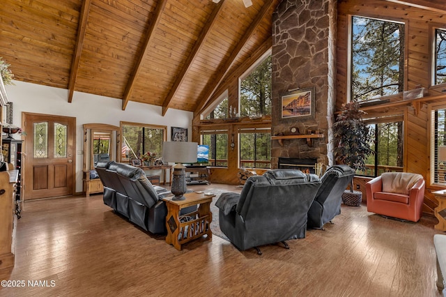 living room with high vaulted ceiling, a fireplace, hardwood / wood-style floors, beam ceiling, and wooden ceiling