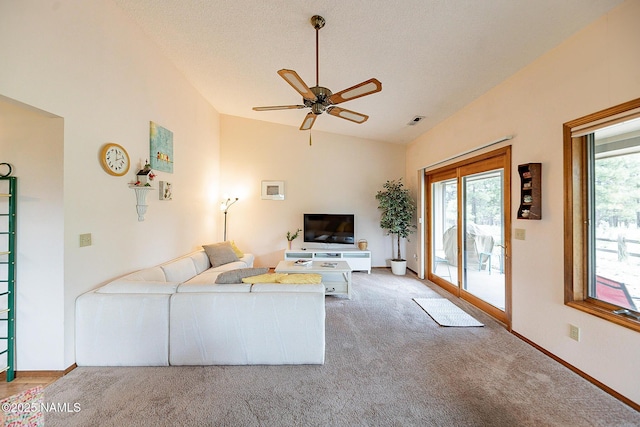 carpeted living room with ceiling fan, plenty of natural light, vaulted ceiling, and a textured ceiling