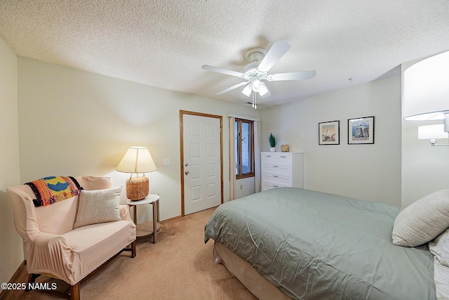 bedroom with ceiling fan, light colored carpet, and a textured ceiling