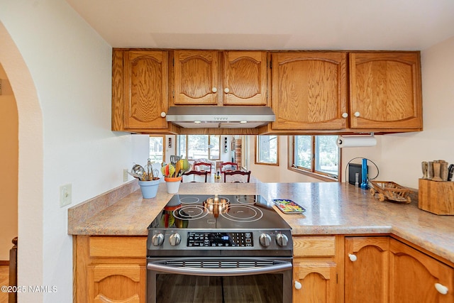 kitchen with stainless steel electric range and a wealth of natural light