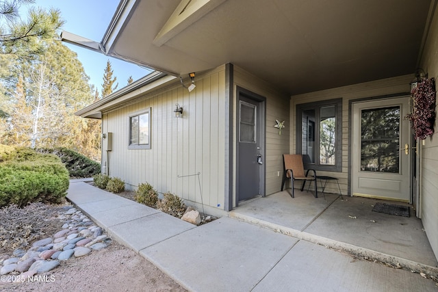 view of exterior entry with a patio area