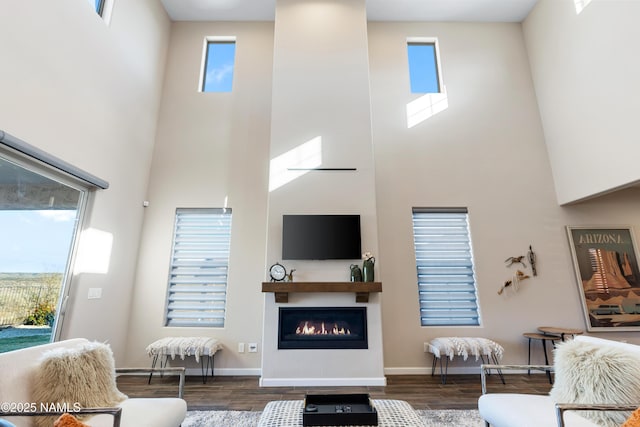 living room with dark wood-type flooring and a high ceiling