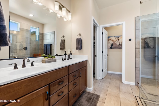 bathroom featuring vanity, a tile shower, and tile patterned flooring