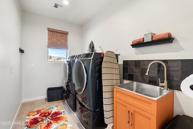 laundry area with sink, separate washer and dryer, and light tile patterned floors