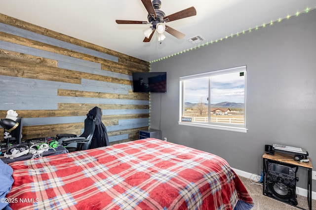 11265 N Zady Ln, Flagstaff, AZ 86004 - carpeted bedroom with wood walls, baseboards, and a ceiling fan