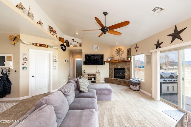 11265 N Zady Ln, Flagstaff, AZ 86004 - living area featuring light carpet, a ceiling fan, vaulted ceiling, baseboards, and a stone fireplace