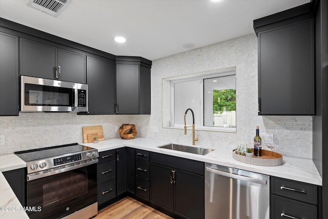 3707 E Amelia Ave, Phoenix, AZ 85018 - kitchen with stainless steel appliances, backsplash, dark cabinets, and light stone counters