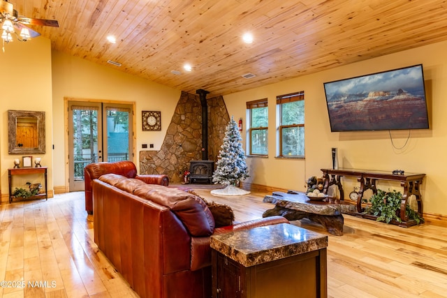 2163 S Highland Mesa Rd, Flagstaff, AZ 86001 - living room featuring wood ceiling, a wood stove, a healthy amount of sunlight, and light wood-type flooring