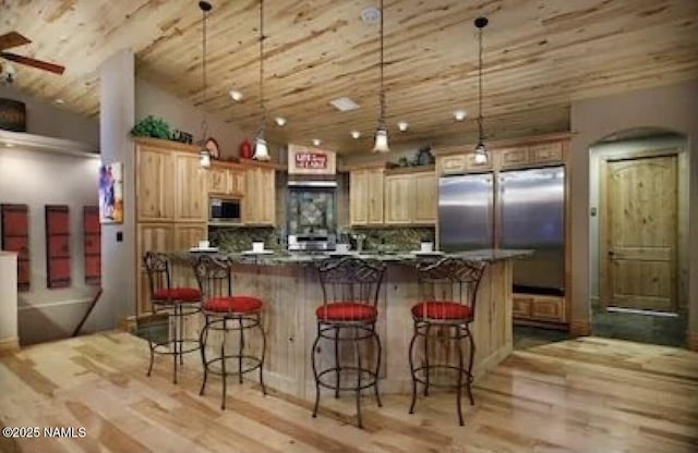 2163 S Highland Mesa Rd, Flagstaff, AZ 86001 - kitchen with pendant lighting, appliances with stainless steel finishes, light hardwood / wood-style floors, backsplash, and a breakfast bar area