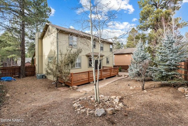 back of house with a wooden deck and central AC unit